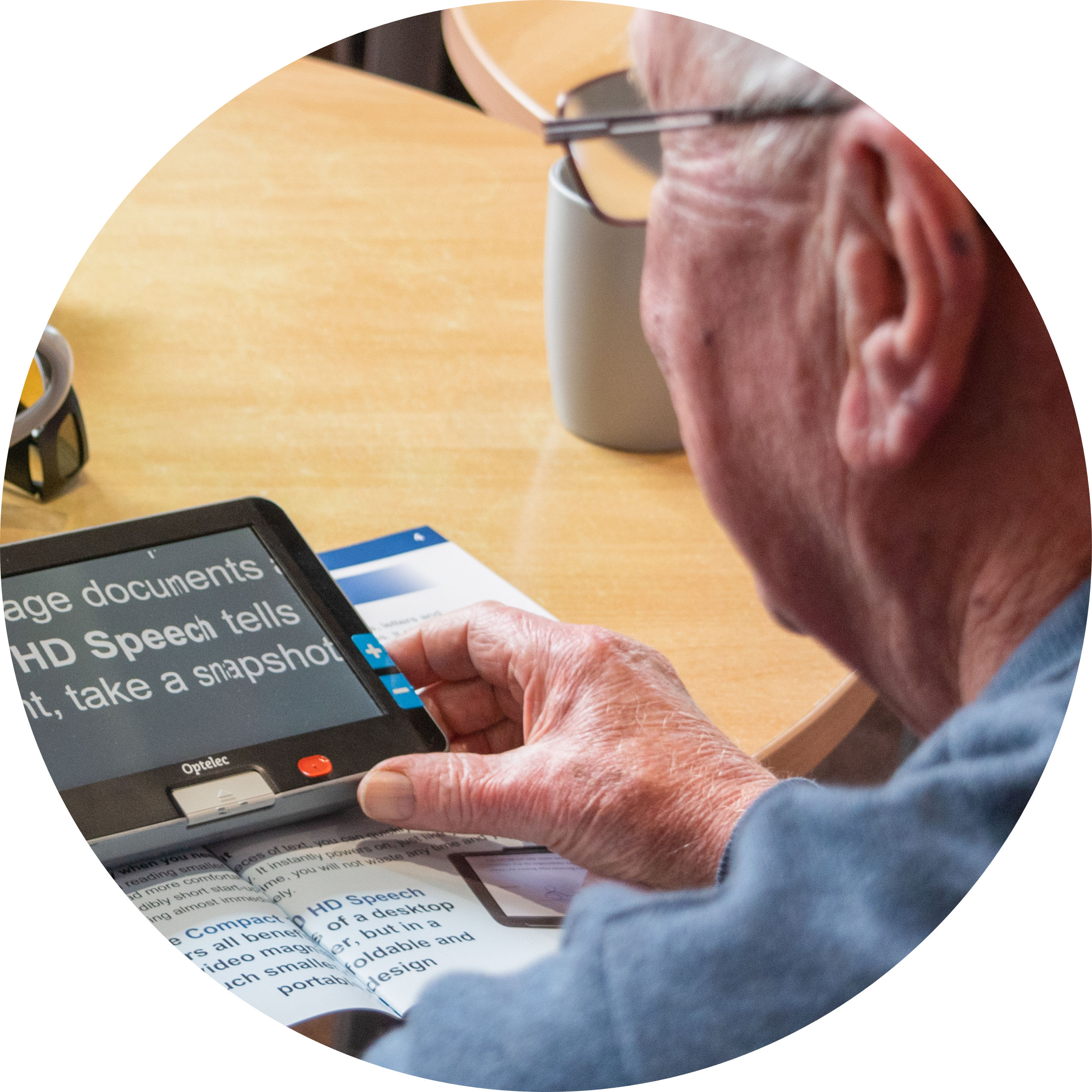 A client using a digital magnifier to read a magazine