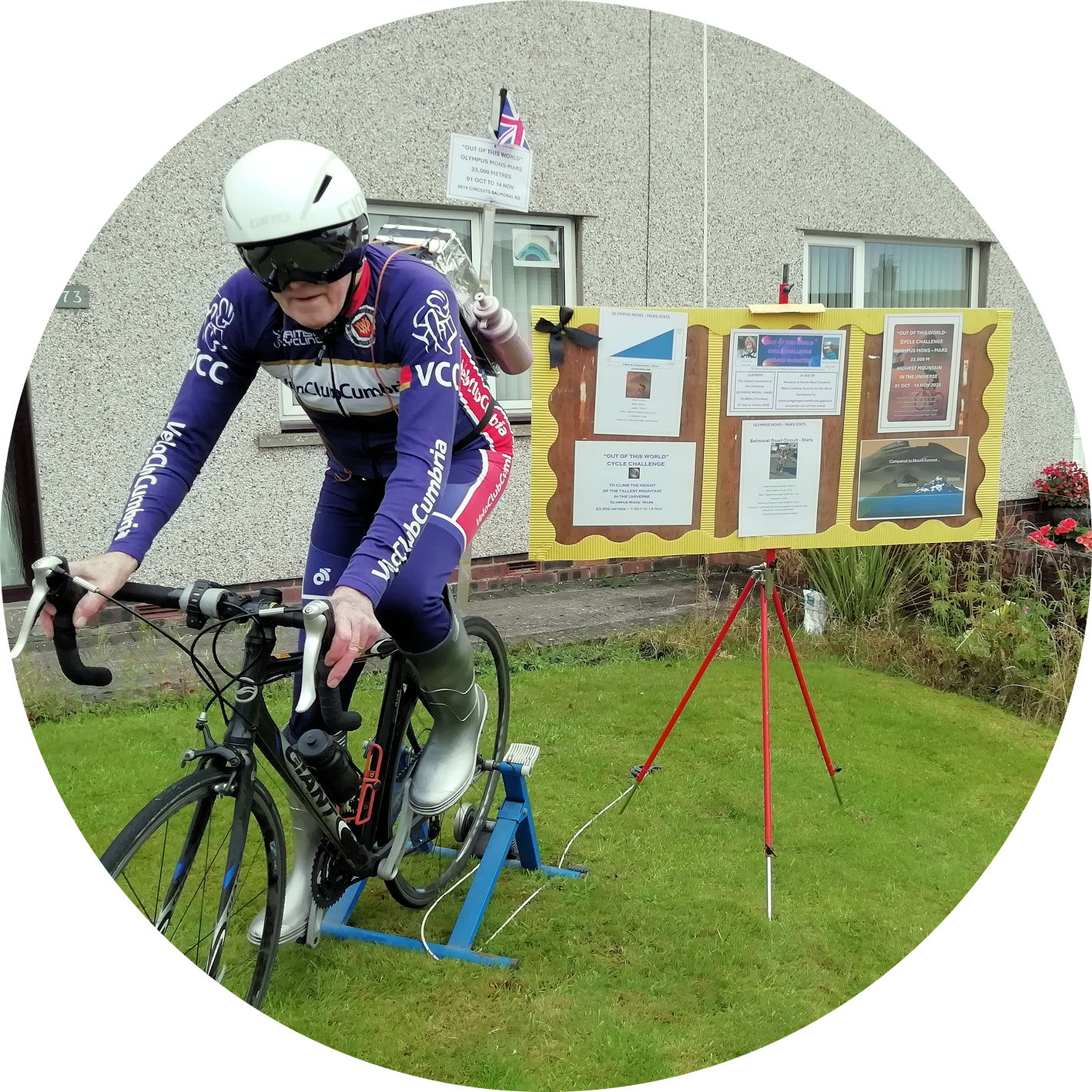 Gerard McCarten on a bike with a presentation board in the background 